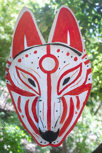 Carboard Kitsune mask hanging on rope photo