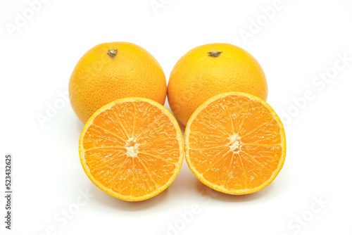 Halved oranges and two oranges look fresh appetizing on white background.