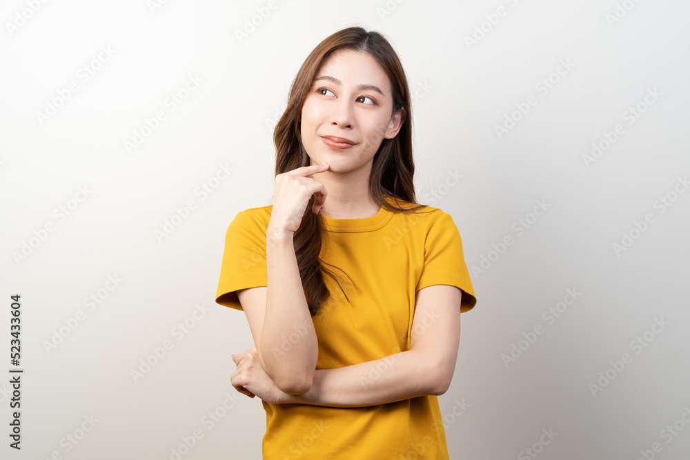 Young female brunette hair in yellow shirt thoughtful isolated on background. Young female brunette hair in yellow shirt thoughtful isolated on background.