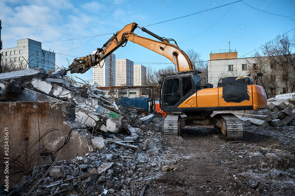 Fototapeta premium Excavator with hydraulic scissors cuts concrete beams