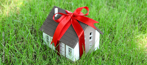 House model with red ribbon...
