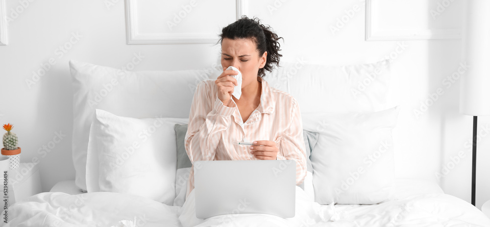 Sick young woman with laptop working at home Sick young woman with laptop working at home