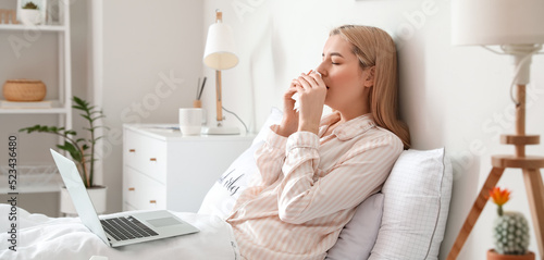 Sick young woman with lapto...