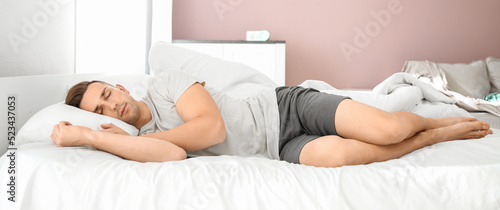 Handsome man sleeping in bed