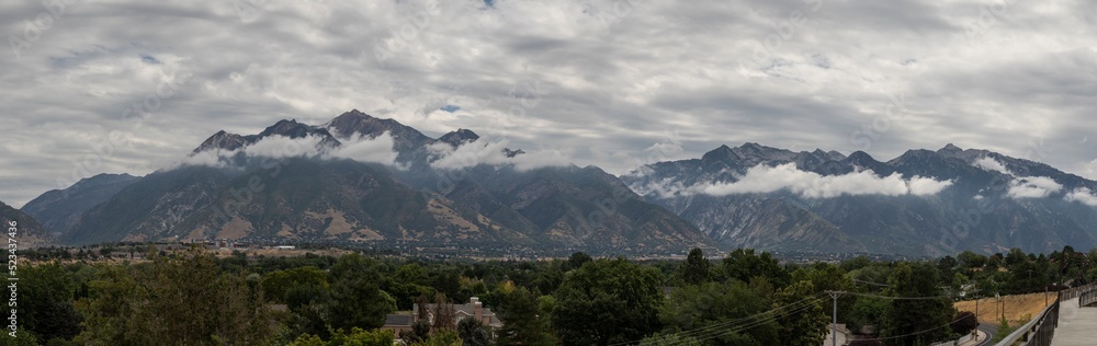 Panorama of the Wasatch mountains as seen from Sandy Utah, with low clouds.