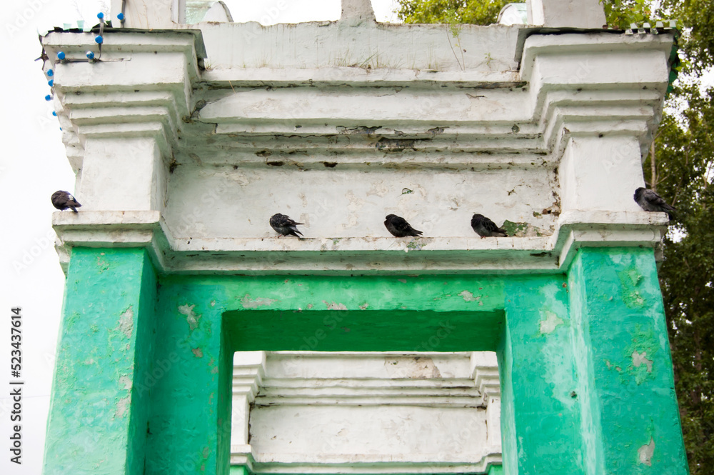 pigeons perched on top of the gate arch