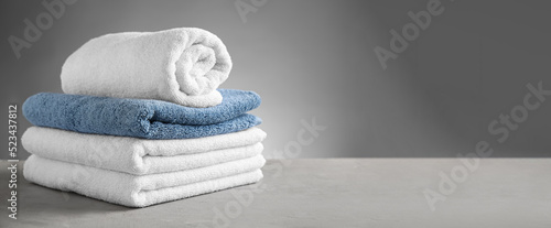 Clean soft towels on table against grey background with space for text photo