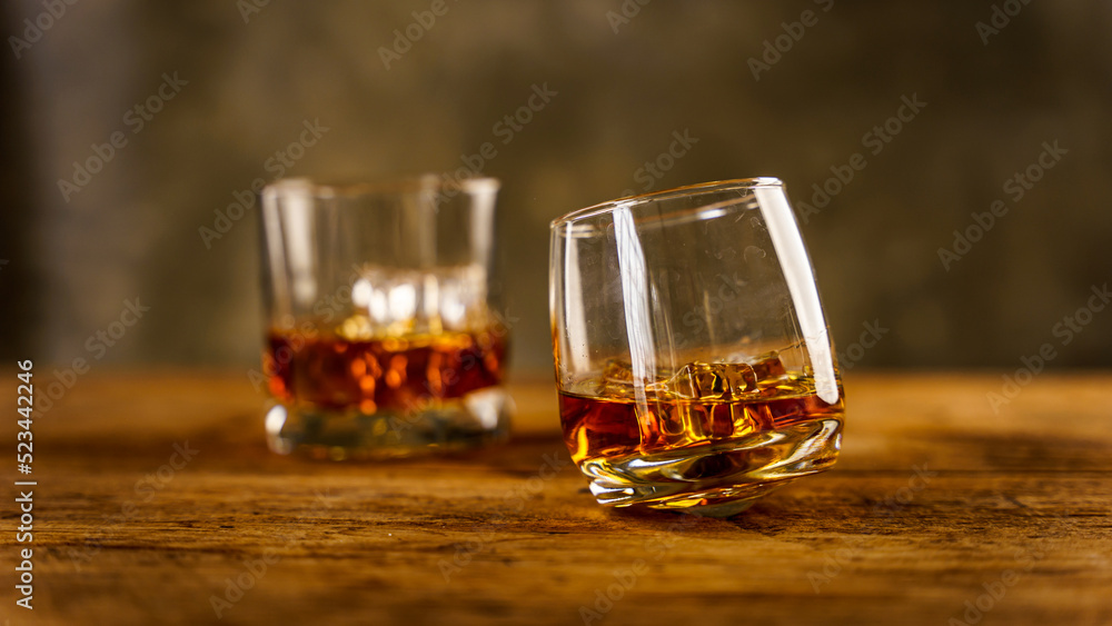 Wiskey in a glass with the ice cubes on the reflective black surface. Bar drinking menu Wiskey in a glass with the ice cubes on the reflective black surface. Bar drinking menu