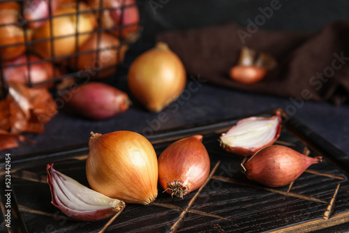 Wooden board with onion on table, closeup