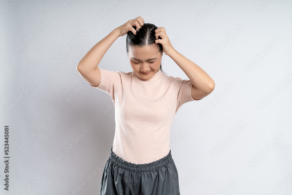 Asian woman scratching her head, standing isolated on white background.