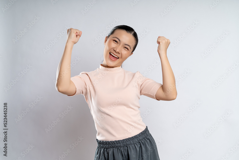 Asian woman happy confident showing her fist make a winning gesture. Asian woman happy confident showing her fist make a winning gesture.