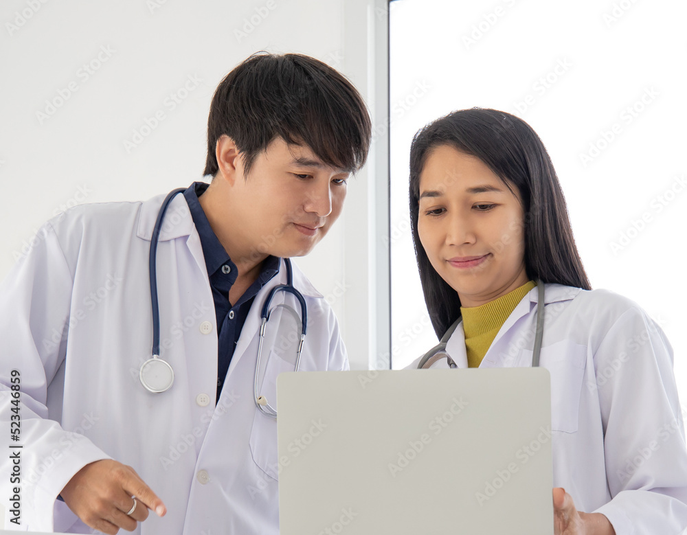 Two professional asian man and woman doctor discussing on laptop to analyse patient person. Two professional asian man and woman doctor discussing on laptop to analyse patient person.