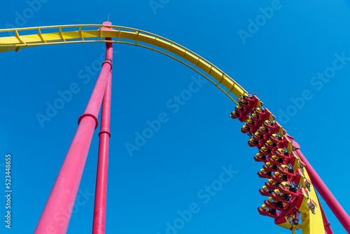 Rollercoaster ride in theme park (against blue sky)
