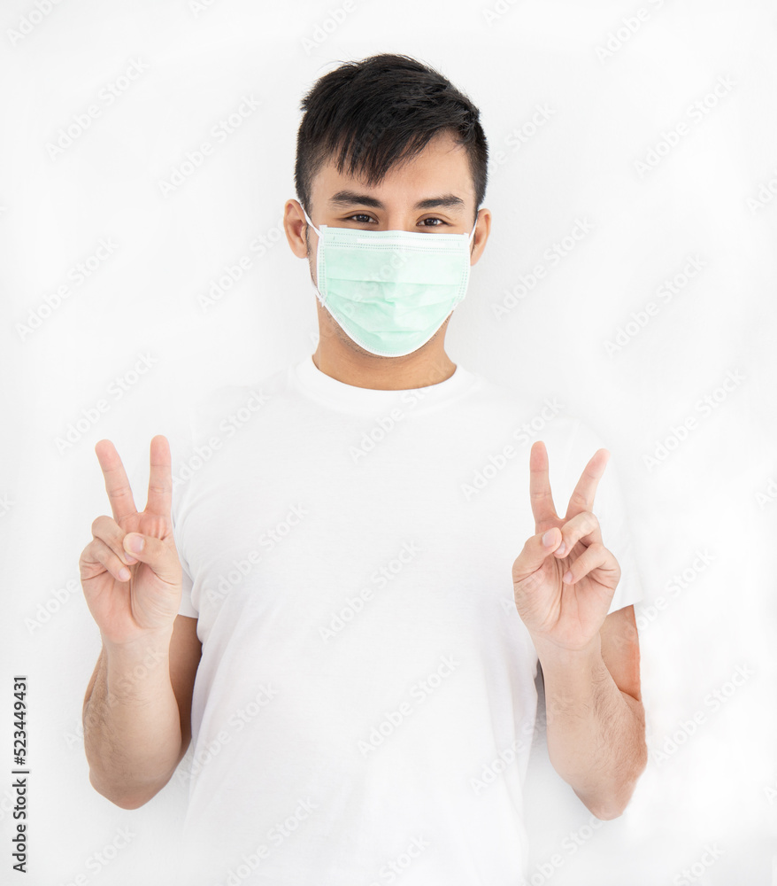 Asian handsome man wearing surgical mask standing overwhite background Asian handsome man wearing surgical mask standing overwhite background