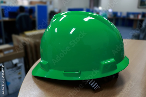 Green safety helmet complete with suspension and chin strap, this head protector is a must-have safety equipment for construction workers.