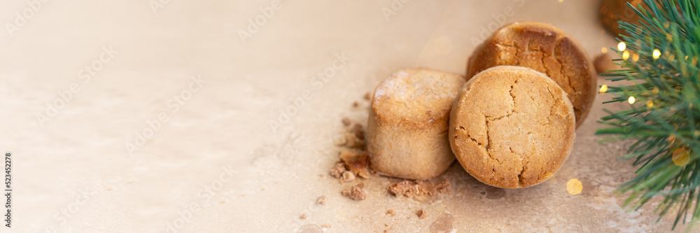 Traditional Spanish sweet Mantecados, soft shortbread with fir tree bunch and bokeh. Christmas sweet . Banner