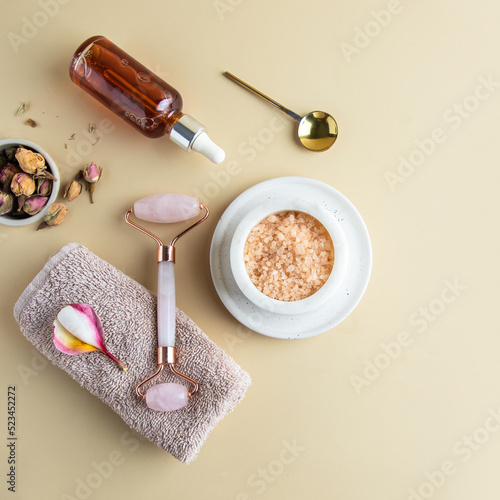 Top view of spa essentials towel with frangipani flower  gua sha massage roller  essential oil   bath salt