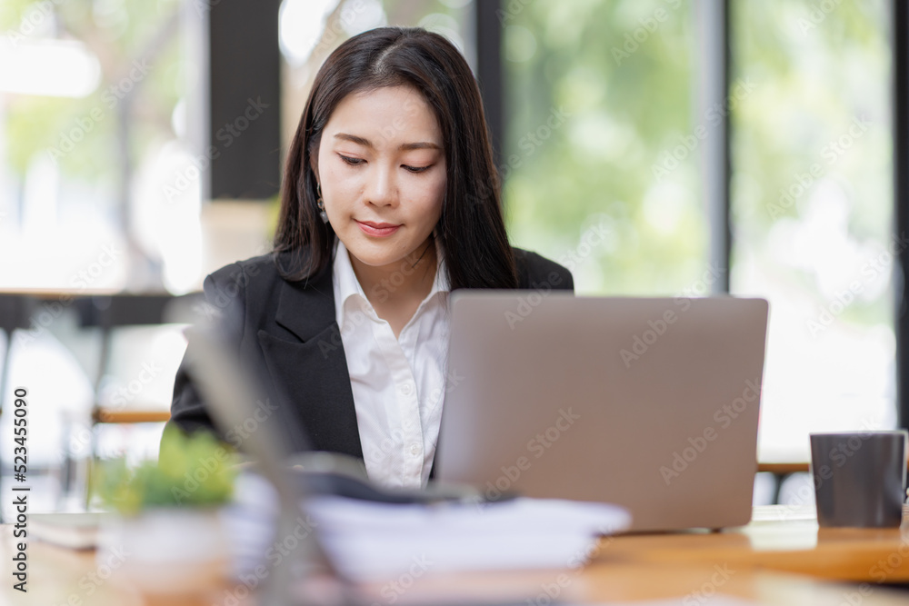 Obraz premium Business Asian woman working with laptop computer and calculator document on an office desk, doing planning analyzing the financial report, business plan investment, finance analysis concept. 