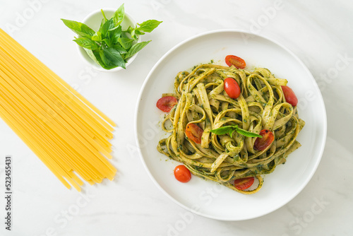fettuccine spaghetti pasta with pesto sauce and tomatoes