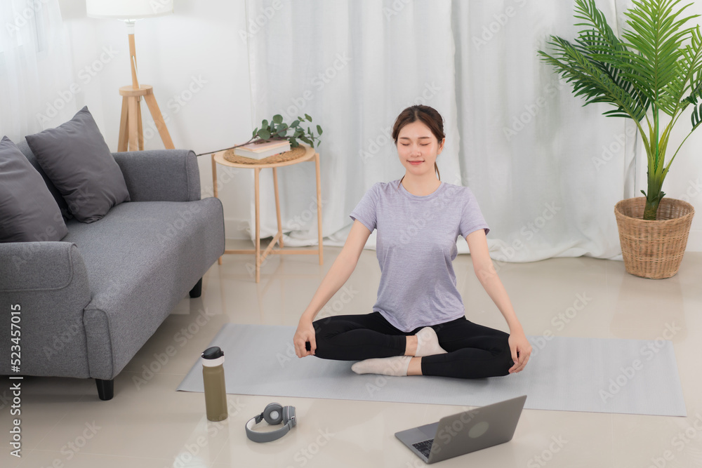 Yoga exercise concept, Young Asian woman with close eyes and meditation doing yoga training online Yoga exercise concept, Young Asian woman with close eyes and meditation doing yoga training online