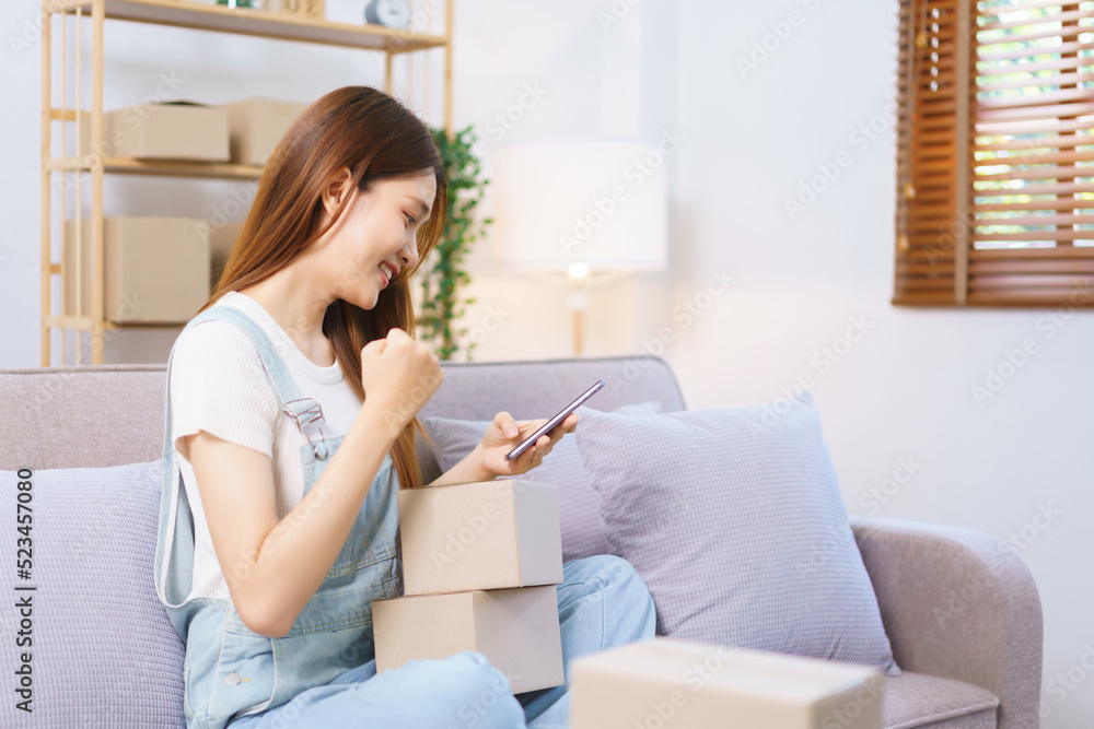 Online seller concept, Female entrepreneur raises arm in celebration after receiving many orders Online seller concept, Female entrepreneur raises arm in celebration after receiving many orders
