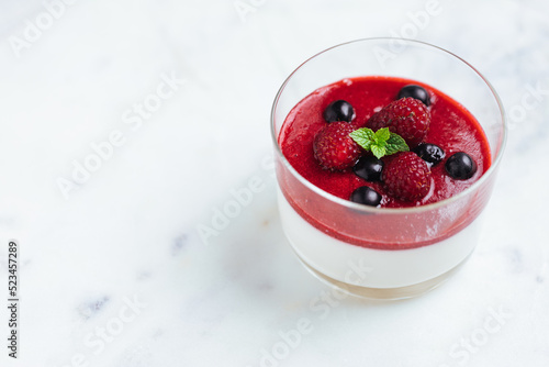 Wallpaper Mural Panna cotta dessert with sauce from berries. Cherries, raspberries and blueberry as decoration. Served in two glasses on dark background. Traditional Italian creamy dessert. Torontodigital.ca