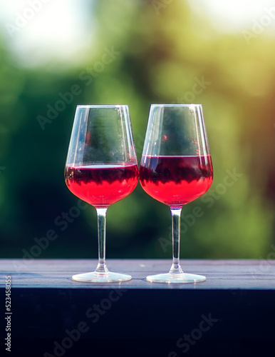 Two glasses of red wine on a table against a blurred background