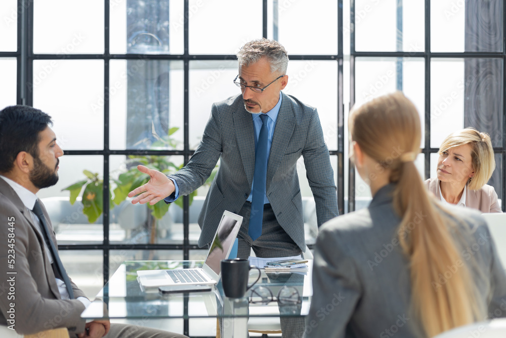 Business team discussing together business plans in office. Business team discussing together business plans in office.