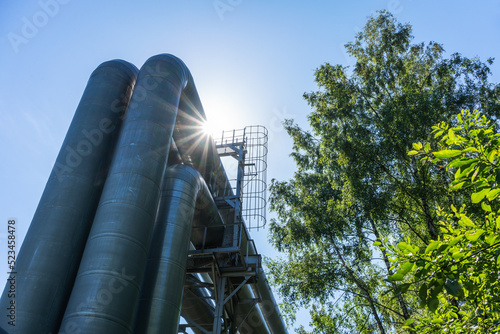 Industrial pipelines on pipe-bridge against blue sky