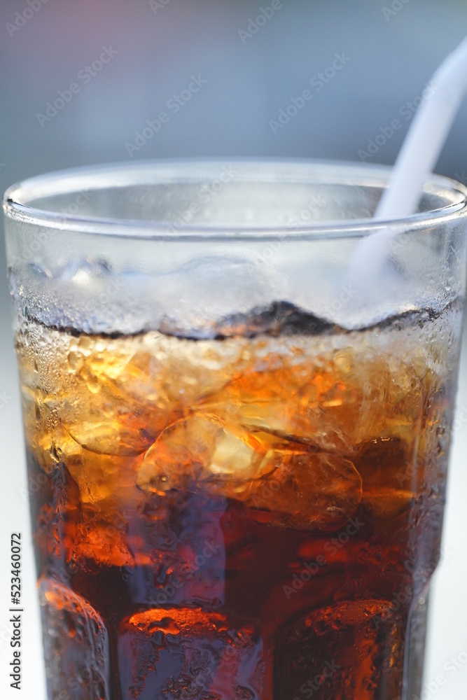 Soft drink in a glass with straws on a table at a restaurant. with blurred background Soft drink in a glass with straws on a table at a restaurant. with blurred background