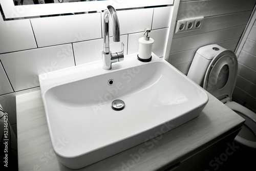 Slika na platnu Big white rectangular washbasin with faucet on wooden countertop in minimalist modern bathroom