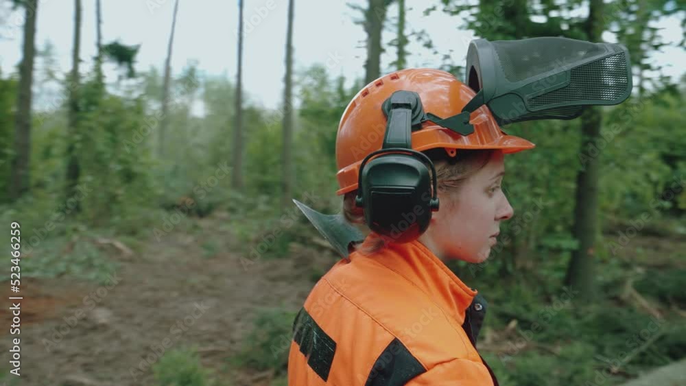 Female logger standing in the forest, a young specialist woman in protective gear, works on deforestation, 4k slow motion. Female logger standing in the forest, a young specialist woman in protective gear, works on deforestation, 4k slow motion.