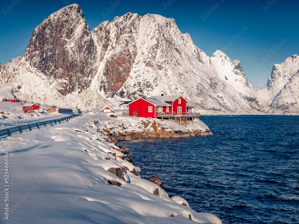 Frosty winter scene of Hamnoy village, Lofoten Islands. Huge snowy peaks on the shore of Norwegian sea. Bright morning view of Norway, Europe. Traveling concept background..