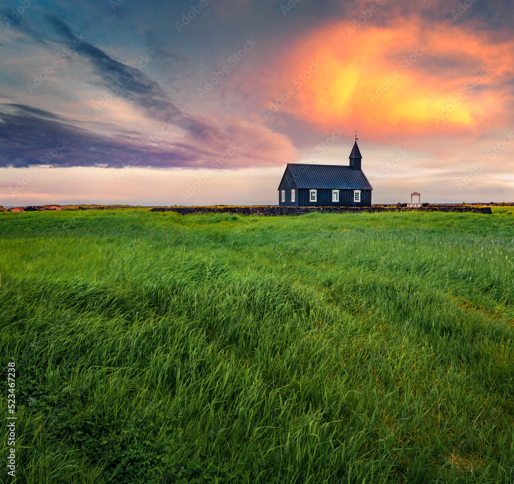 Obraz premium Nice sunrise in Iceland. Black wooden Budakirkja church. Fresh green summer view of Snafellsnes peninsula, western Iceland, Europe. Beauty of nature concept background..