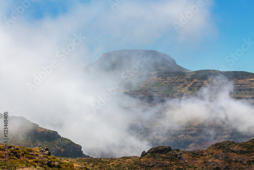 Clouds and fog rise against the table mountain Mesa Fortaleza de Chipude, a huge volcanic plug, Valle Gran Rey, La Gomera, Canary Islands, Spain