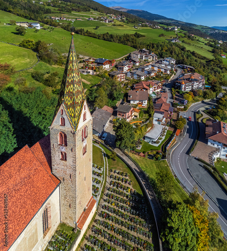 Villandro, Italy - Aerial view of the tower of the Church of St.Michael at the small village of Villandro (Villanders) on a sunny summer day with blue sky in Bolzano photo