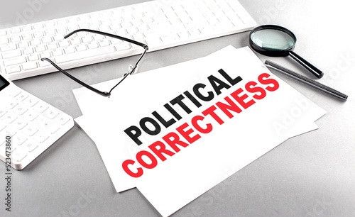 POLITICAL CORRECTNESS text on a paper on a gray background near a calculator and a white keyboard photo