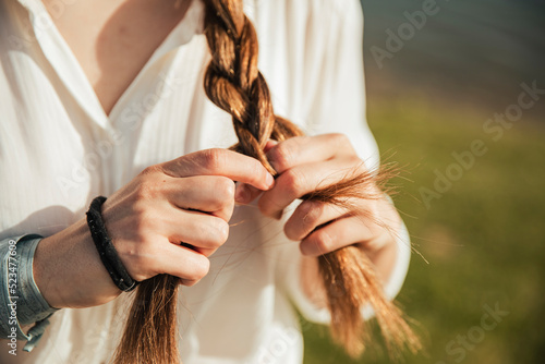 Young woman braiding her hair photo