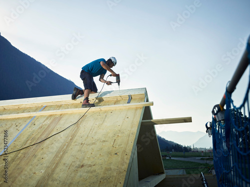 Wallpaper Mural Carpenter with drill working on construction site at sunset Torontodigital.ca