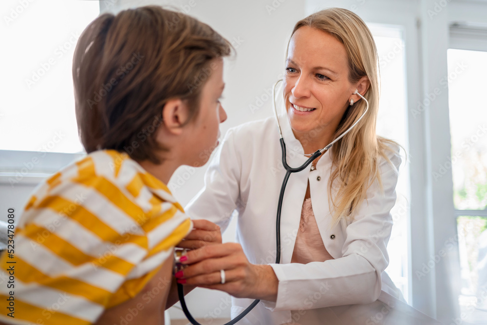Female doctor with stethoscope examining boy Female doctor with stethoscope examining boy