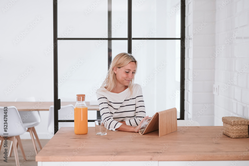 Young woman using tablet PC on table at home Young woman using tablet PC on table at home