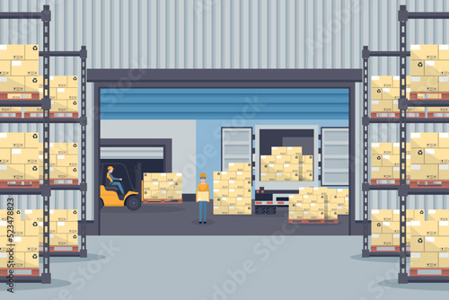 Industrial warehouse for the storage of products with metal racks and shelves for pallet support. Forklift trucks unloading from refrigerated truck. Industrial storage and distribution of products