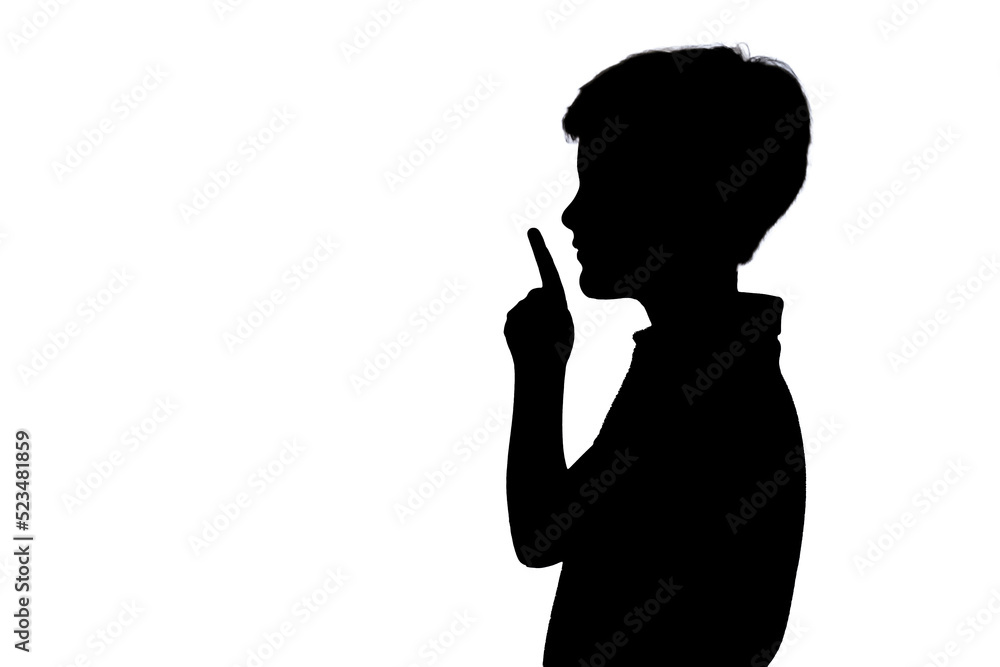 Silhouette emotional teenager holds his index finger to her mouth at isolated white background. Silhouettes contour of boy say no speak. Silent guy looking away. Copy space