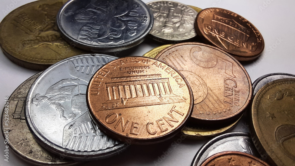 1 Dollar cent coin, with the writing “E Pluribus Unum”, together with a collection of various old coins on a white background. 1 Dollar cent coin, with the writing “E Pluribus Unum”, together with a collection of various old coins on a white background.