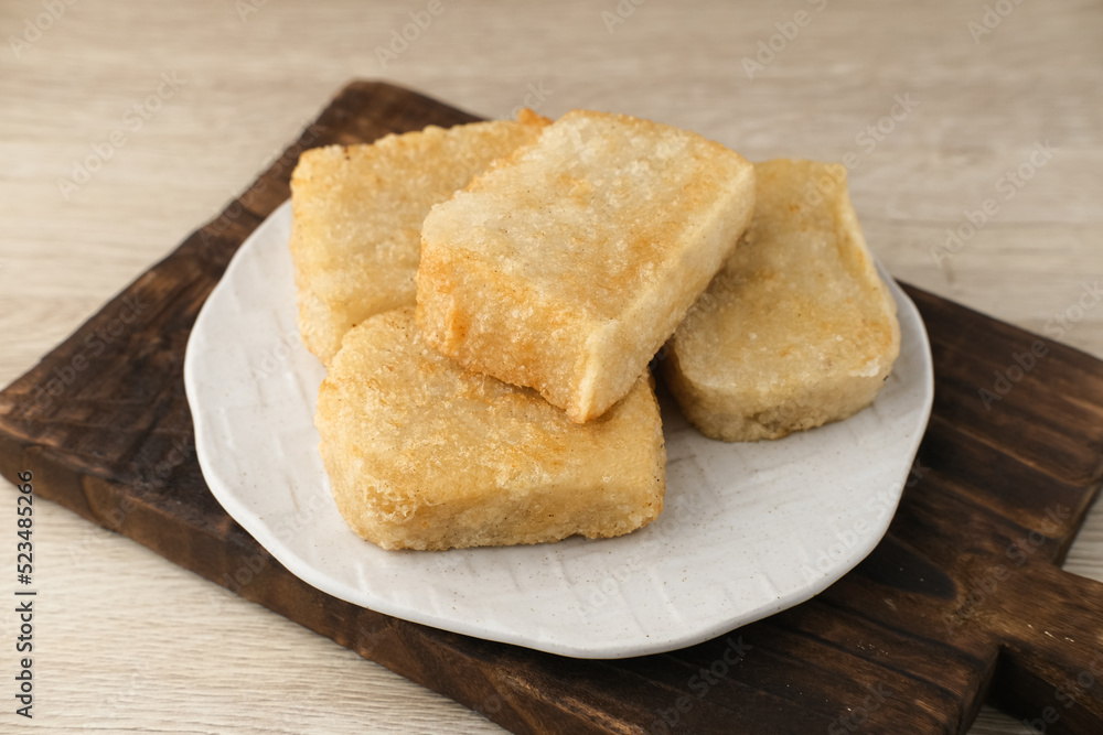 Jadah Goreng or Fried sticky rice cake is Javanese traditional cake made from glutinous rice and grated coconut. Served in white plate, selective focus image.
Jadah Goreng or Fried sticky rice cake is Javanese traditional cake made from glutinous rice and grated coconut. Served in white plate, selective focus image.