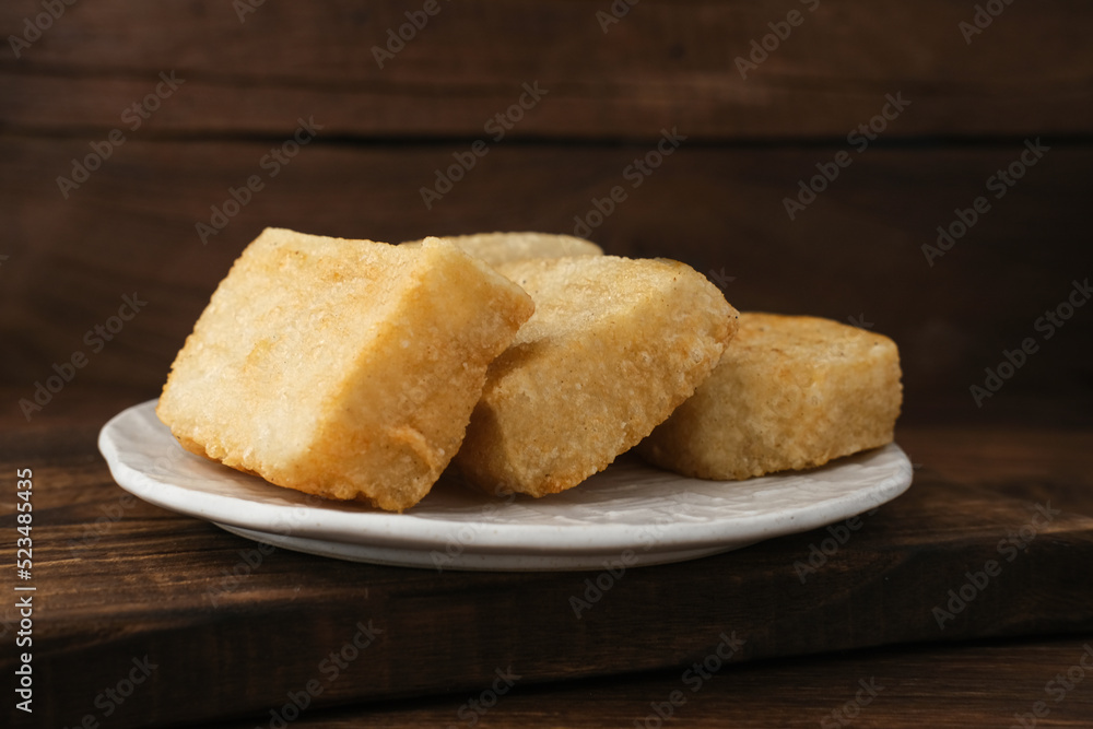 Jadah Goreng or Fried sticky rice cake is Javanese traditional cake made from glutinous rice and grated coconut. Served in white plate, selective focus image.
Jadah Goreng or Fried sticky rice cake is Javanese traditional cake made from glutinous rice and grated coconut. Served in white plate, selective focus image.