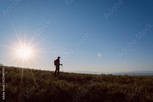 The traveler on the background of the sun. Rising sun. Leto. Kazakhstan. © Arhun