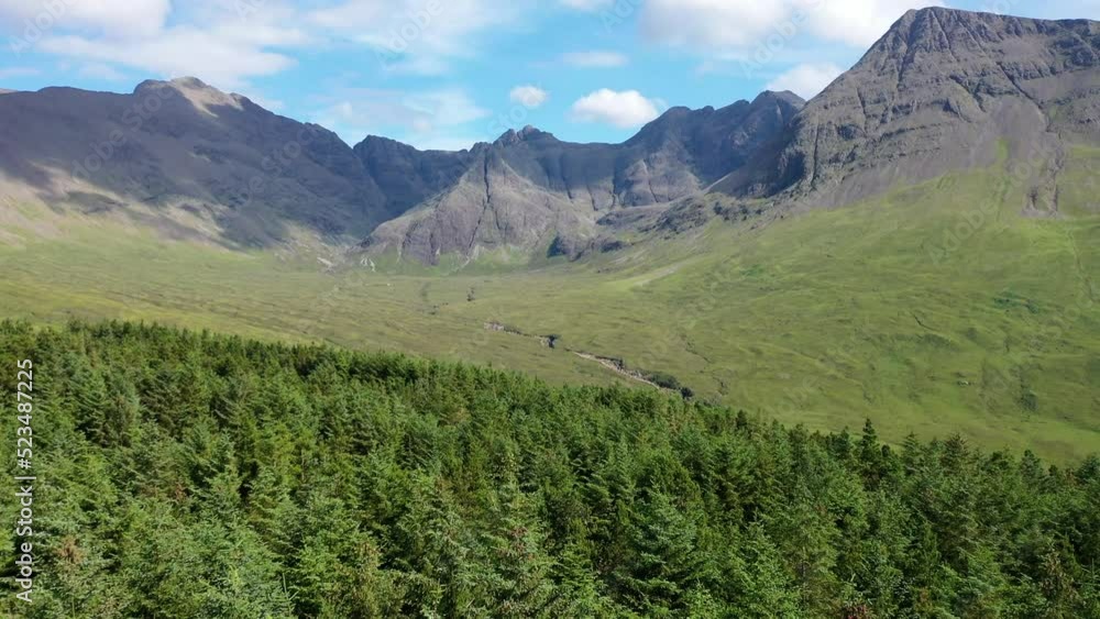 Breathtaking drone shot sweeping over a forest towards the Fairy Pools on The Isle of Skye, Scotland. Breathtaking drone shot sweeping over a forest towards the Fairy Pools on The Isle of Skye, Scotland.