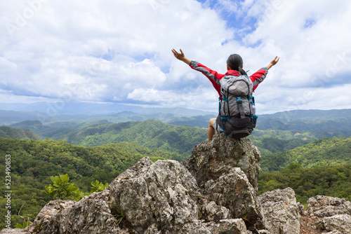 Active climbers enjoy the scenery. Male and female backpackers with backpacks and crutches on top of a mountain.