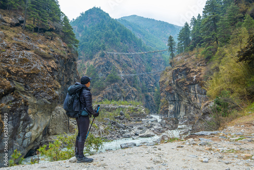 Tourist man looking to Tenzing-Hillary Suspension Bridge, the bridge build for crossing the river in Sagarmatha national park, Nepal, during Everest base camp treks.